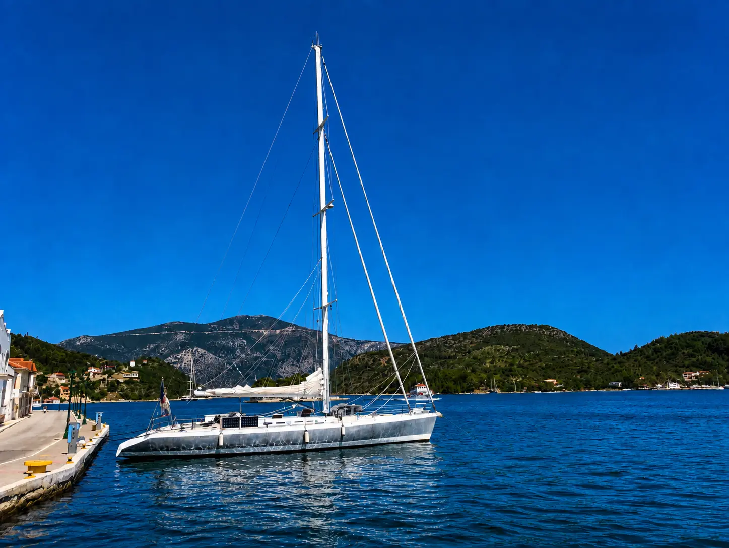 ZORYA Levrier 18 bow view at anchor with bimini and French flag, calm sea