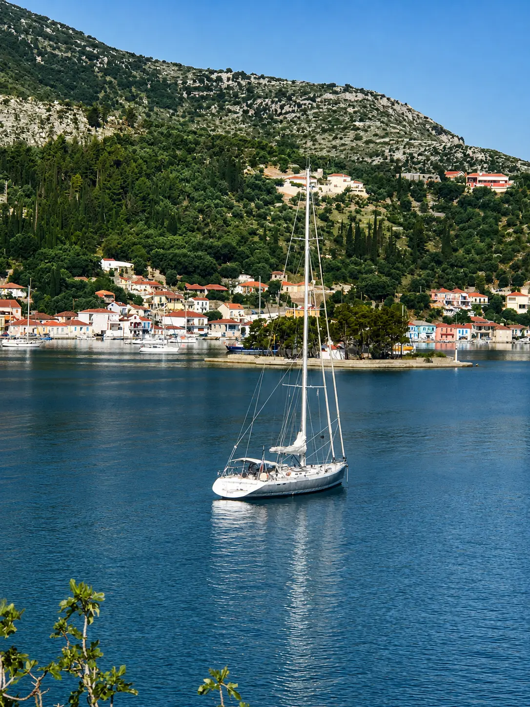 ZORYA transom and cockpit from astern, at anchor on mirror-calm water